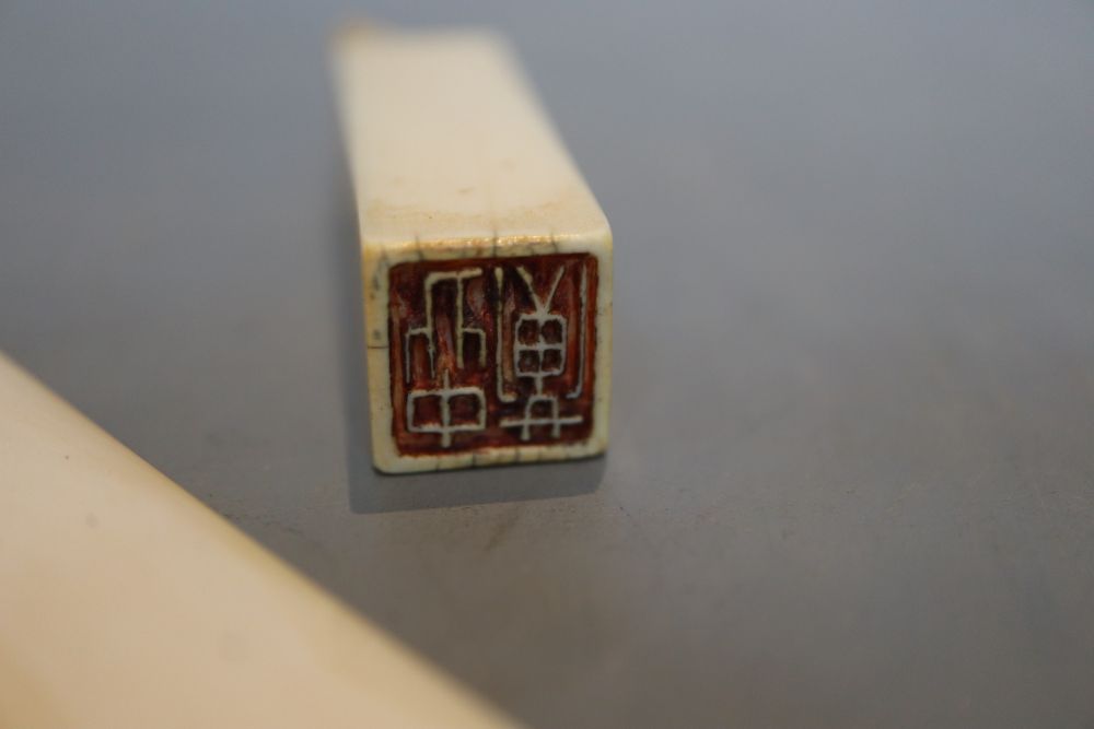 An ivory carving, an ivory seal and an ivory page turner, the handle marked sterling silver, all late 19th or early 20th century,